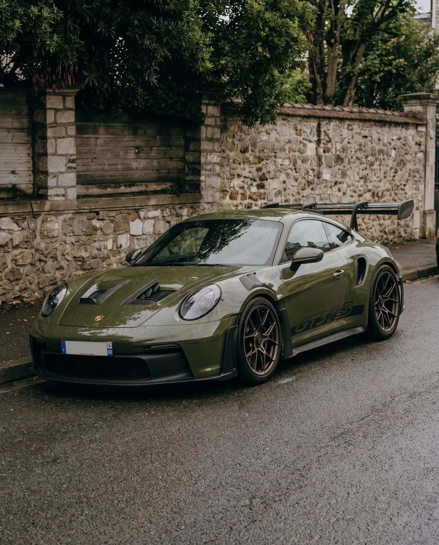 Front three-quarter view by a stone wall